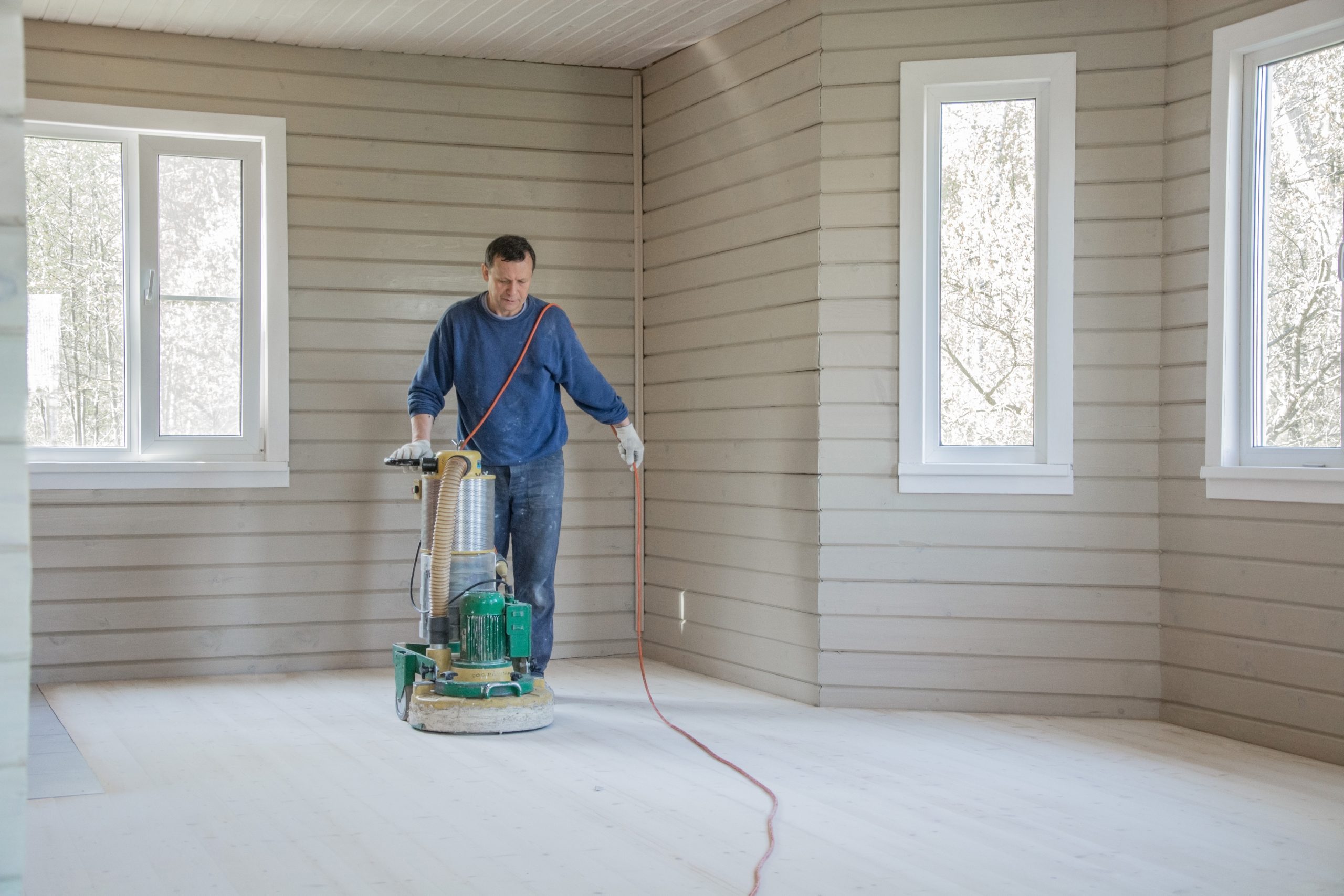 a person resurfacing wooden flooring