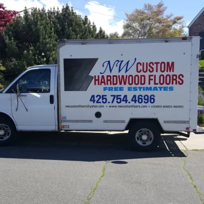 White NW Custom Hardwood Floors box truck with logo, phone number 425-754-4696, and website visible on the side.
